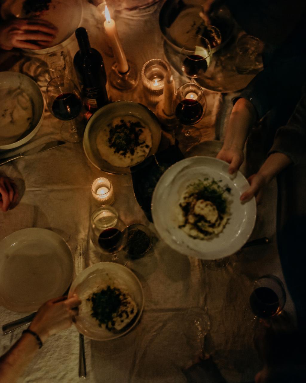 Plates passed across a candlelit dinner table